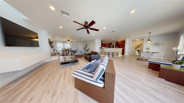 living room featuring ceiling fan and light hardwood / wood-style flooring