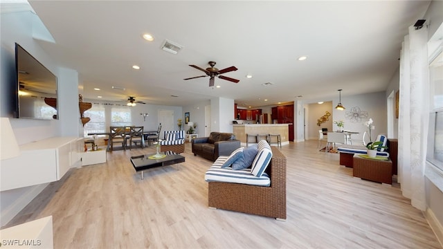 living room featuring ceiling fan and light hardwood / wood-style floors