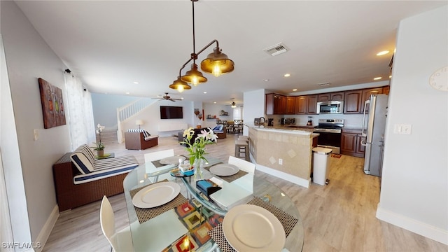 dining room with ceiling fan and light hardwood / wood-style flooring