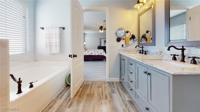 bathroom with hardwood / wood-style flooring, a wealth of natural light, and ceiling fan