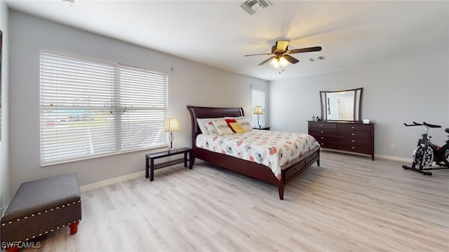 bedroom with ceiling fan, light wood-type flooring, and multiple windows