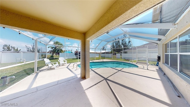 view of pool with glass enclosure, a yard, and a patio