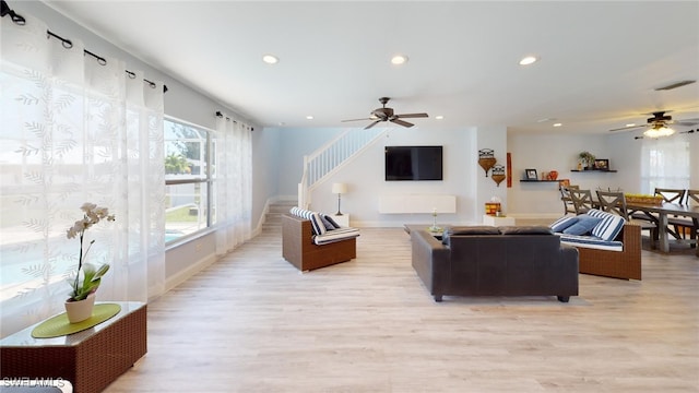 living room with ceiling fan and light hardwood / wood-style flooring