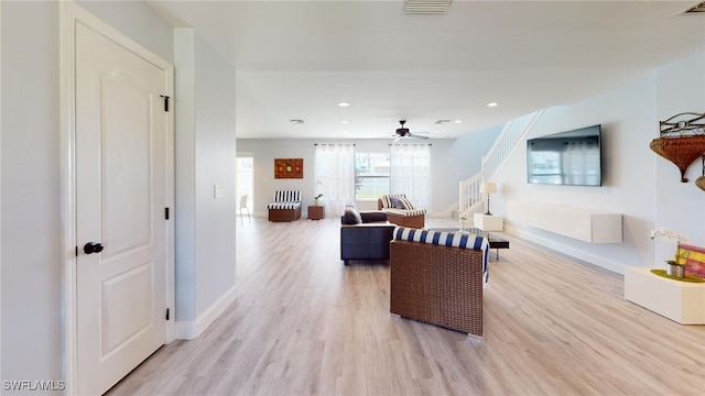 living room featuring ceiling fan and light hardwood / wood-style flooring