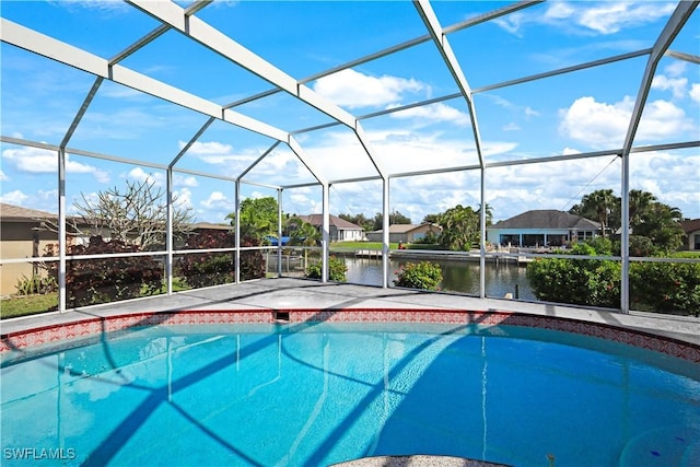 view of pool with glass enclosure and a water view