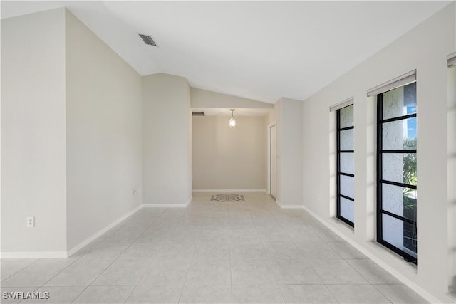 tiled spare room with vaulted ceiling