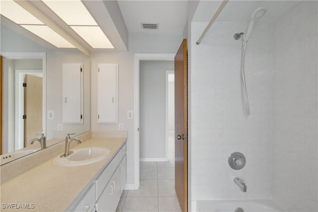 bathroom with tile patterned flooring, tiled shower / bath combo, and vanity