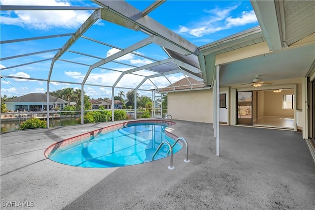 view of swimming pool featuring a lanai, a water view, and a patio