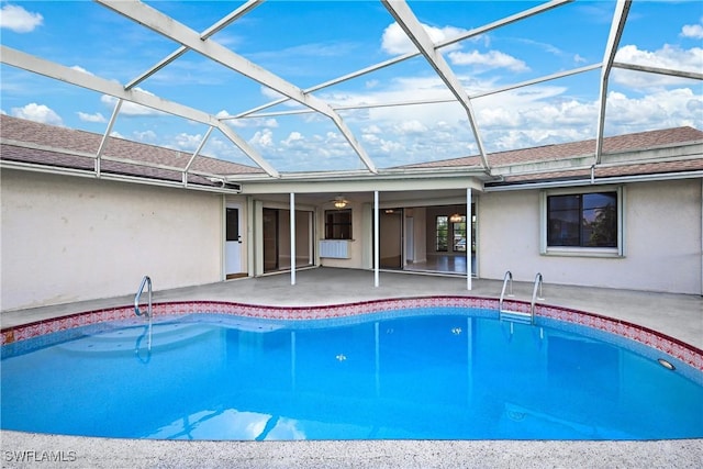 view of pool featuring glass enclosure, ceiling fan, and a patio