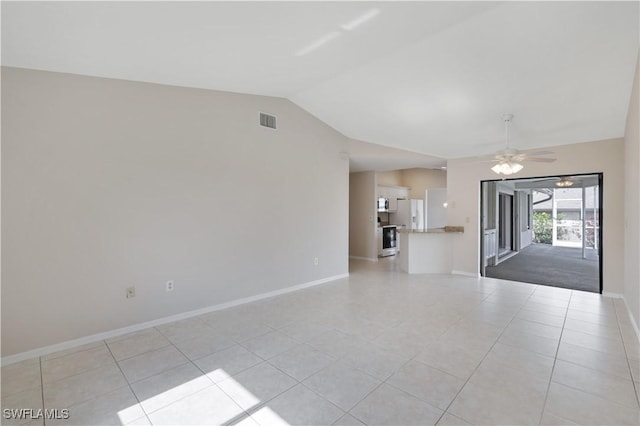 unfurnished living room with ceiling fan, light tile patterned floors, and vaulted ceiling