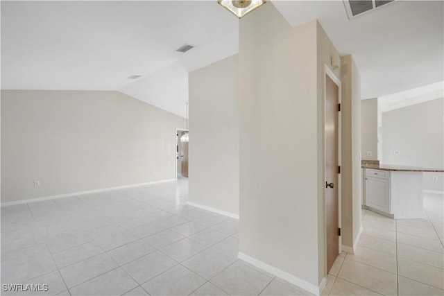 hall featuring lofted ceiling and light tile patterned floors