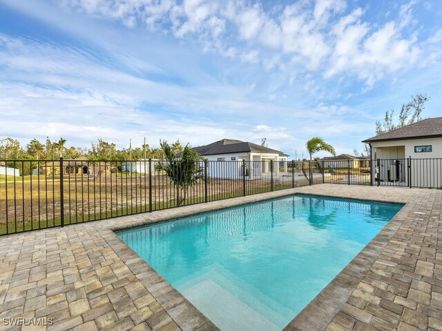 view of swimming pool with a patio area, fence, and a fenced in pool