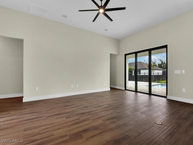 unfurnished room featuring baseboards, dark wood-type flooring, visible vents, and a ceiling fan