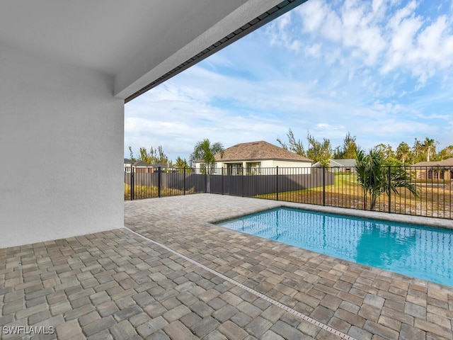 view of swimming pool featuring fence, a fenced in pool, and a patio