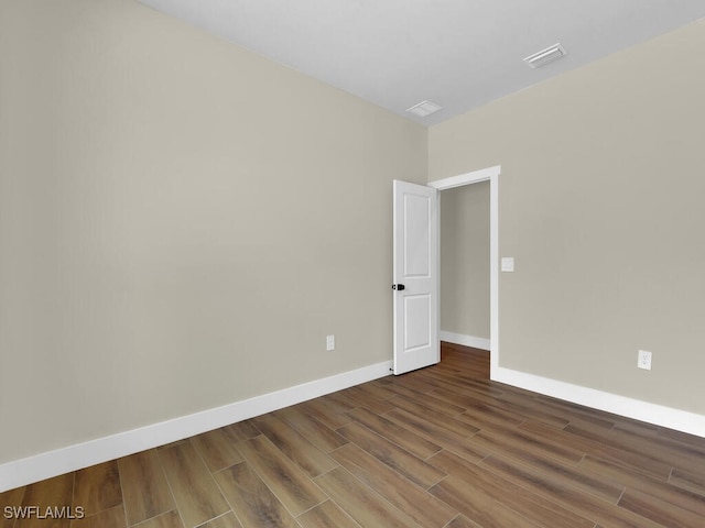 unfurnished room featuring visible vents, baseboards, and wood finished floors