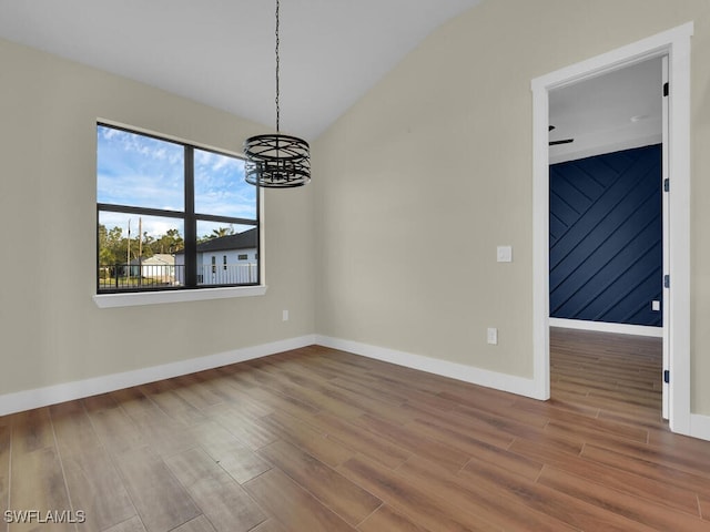 unfurnished dining area with an inviting chandelier, wood finished floors, and baseboards