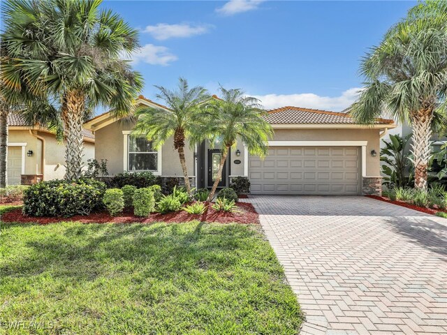 mediterranean / spanish-style home with a front yard and a garage