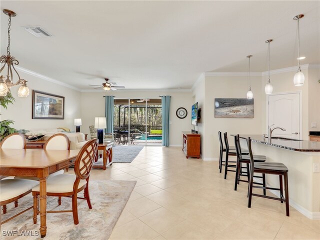 dining area with light tile patterned floors, ceiling fan, crown molding, and sink