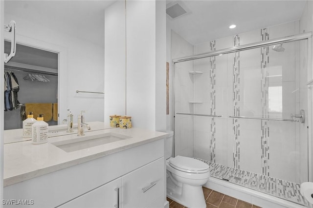 bathroom featuring a shower with door, toilet, and vanity