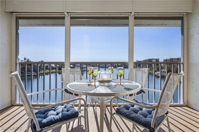 sunroom featuring a wealth of natural light and a water view