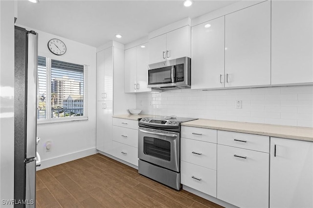 kitchen featuring appliances with stainless steel finishes, decorative backsplash, and white cabinets