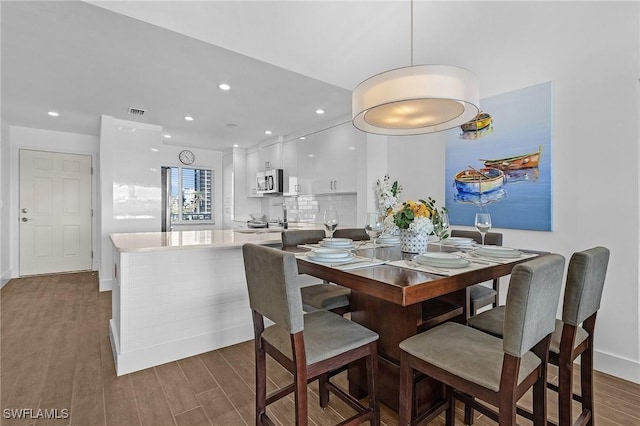 dining space with dark hardwood / wood-style flooring