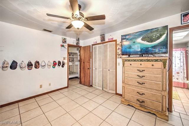 bedroom with a ceiling fan, a closet, visible vents, and light tile patterned flooring