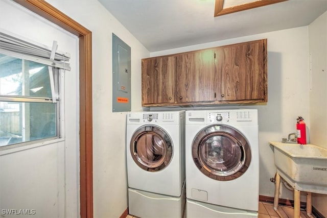 washroom with separate washer and dryer, light tile patterned flooring, cabinet space, and electric panel