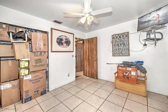 interior space with visible vents, ceiling fan, baseboards, and light tile patterned floors