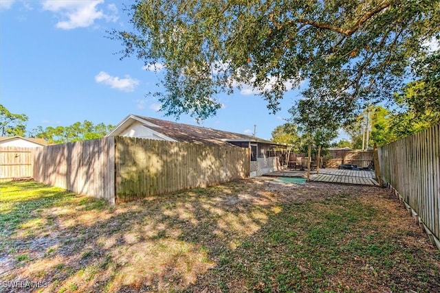 view of yard with a fenced backyard and a wooden deck