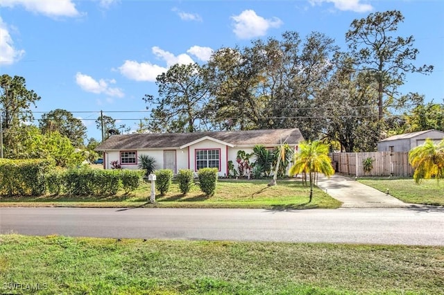 view of front of home with a front lawn, fence, and stucco siding