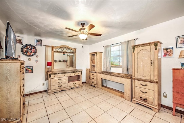 kitchen with a ceiling fan, baseboards, and light tile patterned floors