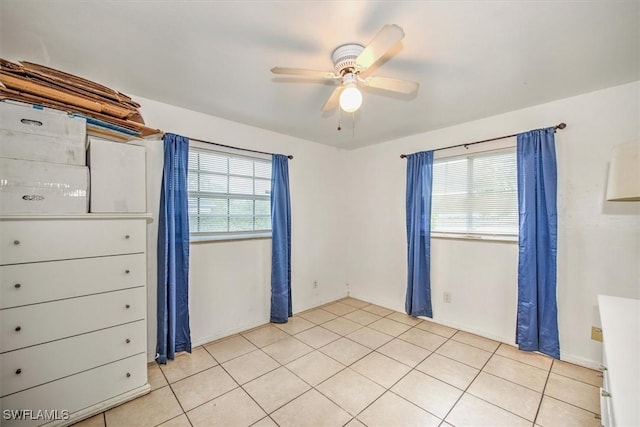 spare room with light tile patterned floors, ceiling fan, and a wealth of natural light