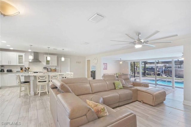 living room with ceiling fan and light hardwood / wood-style floors