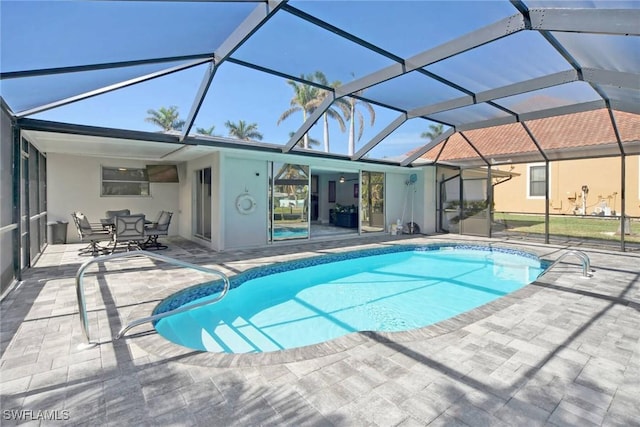 view of swimming pool with glass enclosure and a patio