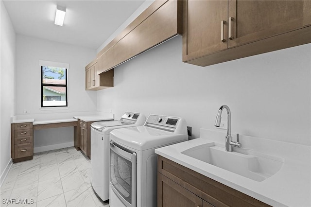 clothes washing area featuring baseboards, marble finish floor, a sink, cabinet space, and washing machine and dryer