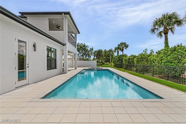 view of swimming pool featuring a fenced backyard, a pool with connected hot tub, and a patio