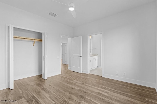 unfurnished bedroom with connected bathroom, ceiling fan, a closet, and light wood-type flooring