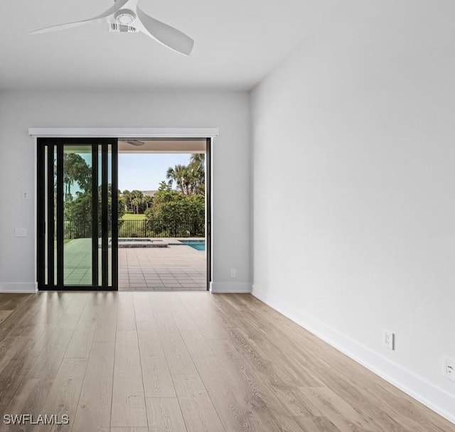 unfurnished room featuring ceiling fan, wood finished floors, and baseboards