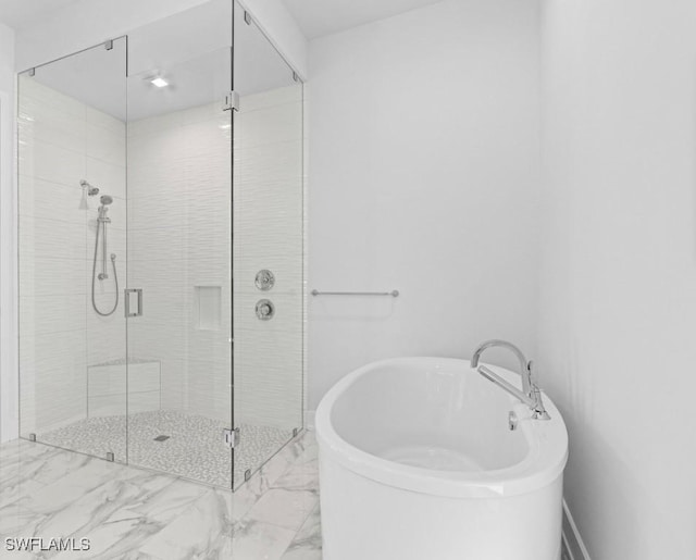 bathroom with marble finish floor, a stall shower, and a soaking tub