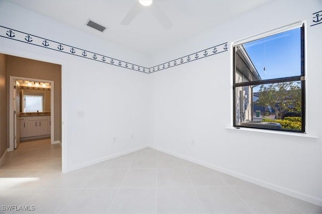 spare room featuring light tile patterned floors and ceiling fan