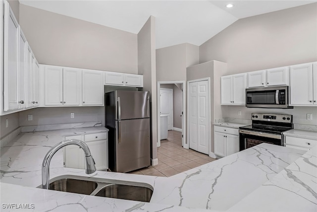 4490 10th St NE, Naples, FL 34120 - kitchen featuring stainless steel appliances, high vaulted ceiling, light stone counters, white cabinets, and light tile patterned floors