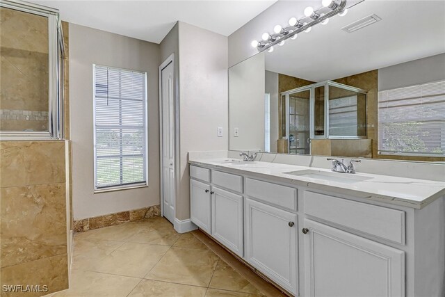 bathroom featuring tile patterned floors, vanity, and a shower with shower door