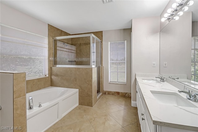 bathroom with tile patterned flooring, vanity, a wealth of natural light, and plus walk in shower