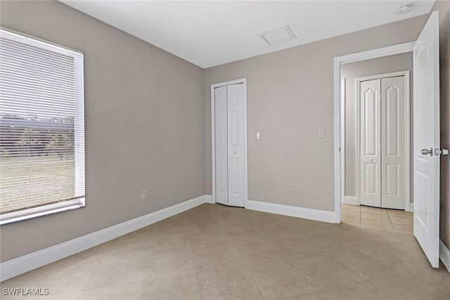 unfurnished bedroom featuring light tile patterned floors and baseboards