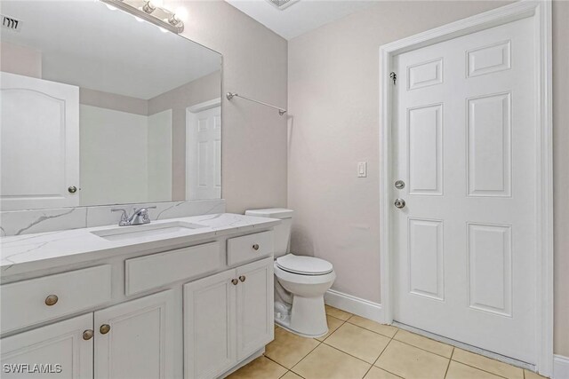 bathroom with tile patterned flooring, vanity, and toilet