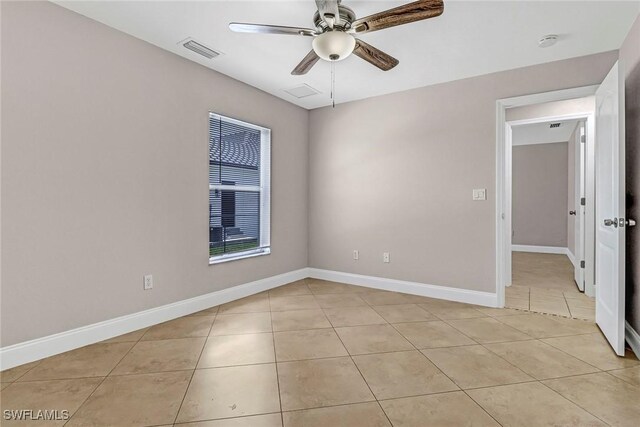 empty room with ceiling fan and light tile patterned flooring