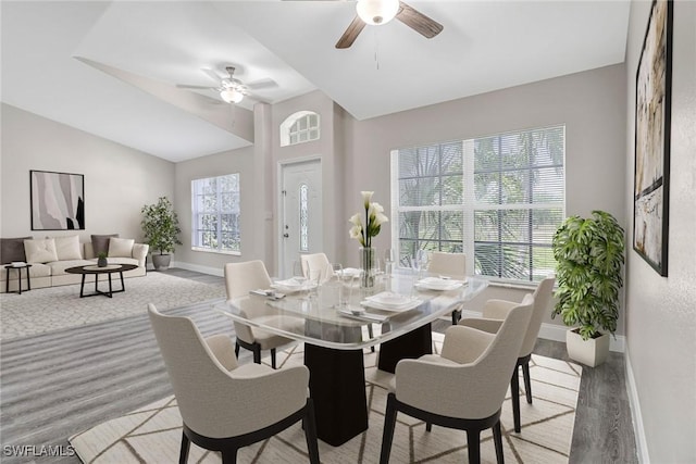 dining area featuring ceiling fan, vaulted ceiling, and light wood-type flooring