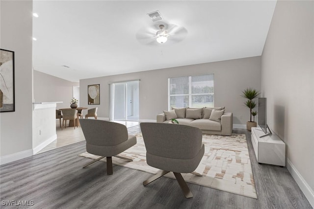 living room featuring ceiling fan, light hardwood / wood-style floors, and lofted ceiling