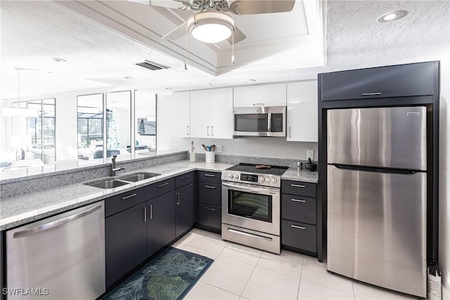 kitchen with sink, white cabinets, a textured ceiling, and stainless steel appliances